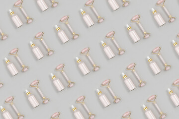 Cosmetic pattern. Crystal rose quartz facial roller and anti-aging collagen, serum in glass bottle on grey background. Facial massage for natural lifting, Beauty concept Top view Flat lay