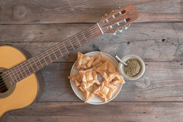 Overhead view of a guitar, mate and quince and sweet potato pancakes on the rustic wooden...