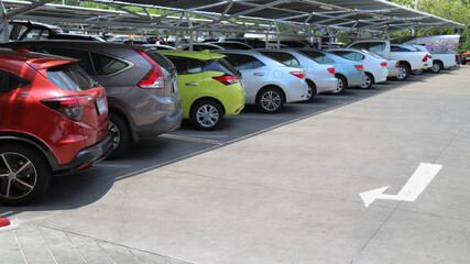 Closeup of rear, back side of red car with  other cars parking in indoor parking area.