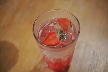 Close up of a glass of ice strawberry squash.