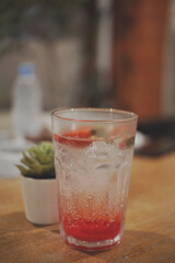 Close up of a glass of ice strawberry squash.