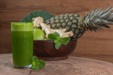 glass of juice and fresh ingredients for preparing detox green juice