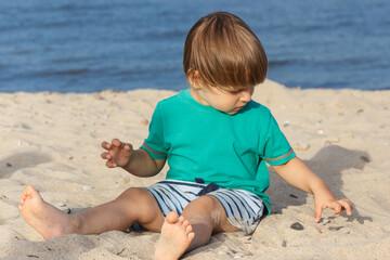 Baby boy on summer beach. Vacation time and child development concept