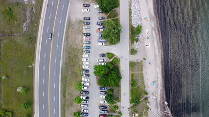 aerial view of a road and a parking lot beside a coastline in the summer