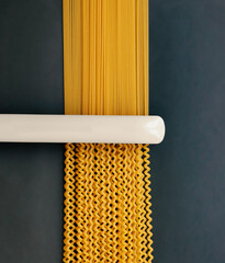 Curly pasta straightening concept. Flat iron on pasta composition.