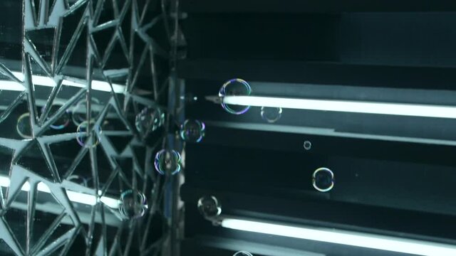 Foam bubbles fliing on neon mirror background. Abstract wonderfull background, workpiece for space design. Slow motion