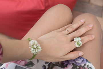 Obraz na płótnie Canvas Female hand in a four-leaf clover flowers ring.