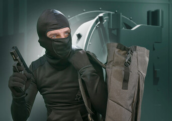 heist and robbery - Hollywood style portrait of man in balaclava mask holding gun in front of...