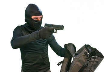 heist and robbery - Hollywood style portrait of man in balaclava mask holding gun in front of security metal vault door in bank or casino heist concept stealing money unlocking safe