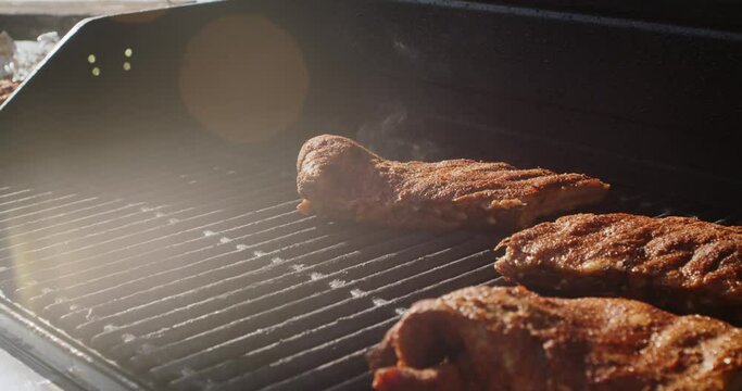 Juicy rack of ribs cooking on a bbq grill on a summer afternoon