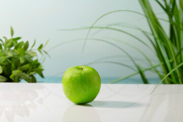 a delicious looking green apple on a table on an out of focus background. Healthy and vegan food...