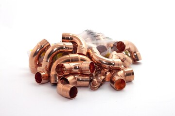 Closeup shot of the curved copper fittings for plumbing isolated on white background