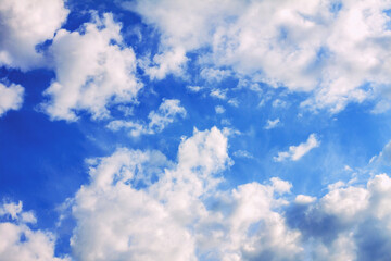 Many white and gray clouds of different sizes against a clear blue sky