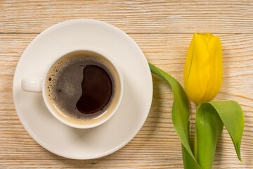 yellow tulip and white coffee cup on white wooden table, good morning concept