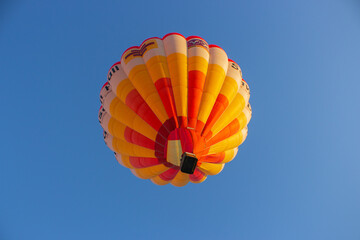Kyiv, Ukraine - 06/26/2020: Hot air balloon in clear sky, bottom view. Colorful balloon on blue...