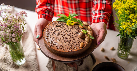 Delicious mousse nut cake decorated with nuts and green leaves. Concept of delicious and healthy...