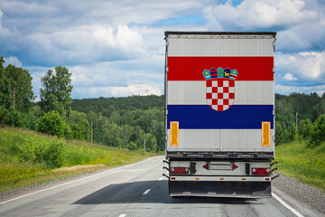 A  truck with the national flag of Croatia. depicted on the back door carries goods to another...