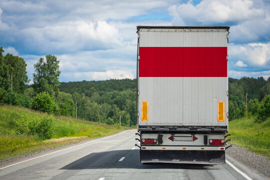 A  truck with the national flag of Indonesia. depicted on the back door carries goods to another country along the highway. Concept of export-import,transportation, national delivery of goods