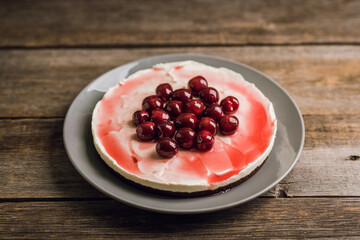 Fresh cheesecake with cherries on the rustic background. Selective focus. Shallow depth of field.
