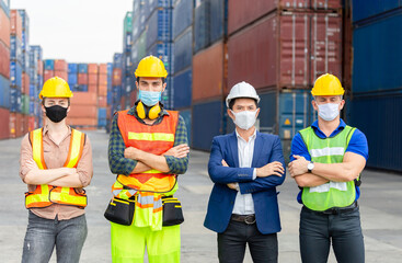 Success Teamwork Concept, Business people engineer and worker team wearing protection face mask against coronavirus with arms crossed as sign of success blurred container box background