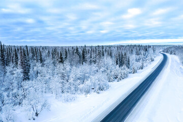 Aerial view on the road and forest at the winter time. Natural winter landscape from air. Forest...