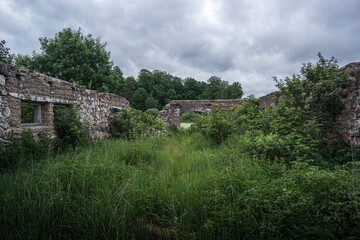 Ruins of old estate buildings made from red brick and stone.