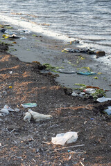Spilled garbage on the beach of the big city. Empty used dirty plastic bottles. Dirty sea sandy shore the Black Sea. Environmental pollution. Ecological problem