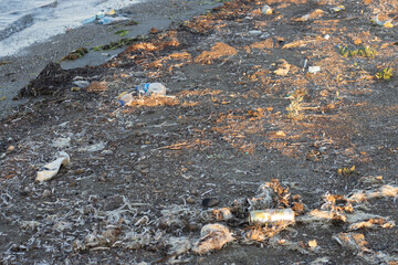 Spilled garbage on the beach of the big city. Empty used dirty plastic bottles. Dirty sea sandy shore the Black Sea. Environmental pollution. Ecological problem