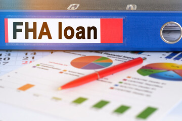 On the table are pie charts, a pen and a folder with the inscription - FHA loan.