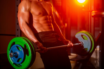 Close up training with barbell. Man lifting barbells working out in gym. Closeup deadlift barbells workout. Sporty man lifts barbell in gym. Workout the gym. Athletic man with six pack, perfect abs