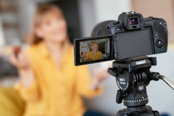 Female vlogger recording makeup tutorial for her channel. Young beautiful woman recording make up...