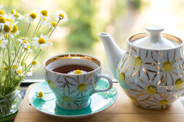 A cup of chamomile tea on the table, a vintage old tea party photo