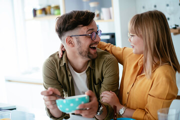 Young couple eating breakfast at home. Loving couple enjoying in morning..	