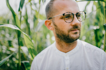 Portrait of a handsome man with short hair, black bristles on his face with glasses and a white shirt