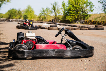Red sports kart without a racer close-up on a parking lot of a ring road race