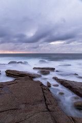 Fototapeta na wymiar Seascape view of water flowing into rock formation.