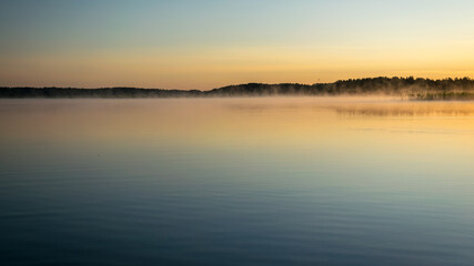 Foggy weather early in the morning on the lake. beautiful wallpapers. a mystical mist vibrates in the lake. summer sunrise