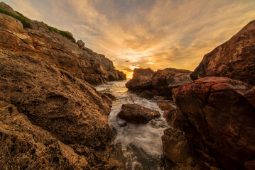 Sunrise between the rocks of the renega in Oropesa
