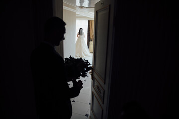 very beautiful is bride meeting with her groom and bridesmaids watching in the room