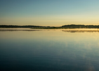 Foggy weather early in the morning on the lake. beautiful wallpapers. a mystical mist vibrates in the lake. summer sunrise