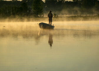Fototapeta premium Foggy weather early in the morning on the lake. beautiful wallpapers. a mystical mist vibrates in the lake. summer sunrise