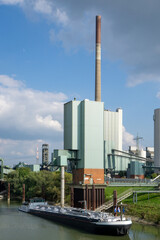Naklejka premium Binnenschiff vor Industrie Kulisse