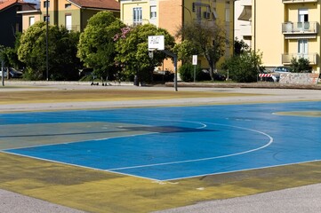 Basketball hoop shadow on a colored playground field (Pesaro, Italy, Europe)