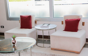 White sofa chair and red pillows