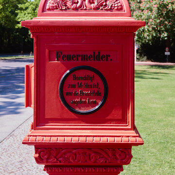 a beautiful nostalgic red fire alarm on the street in Germany, ranslation german text: firelarm