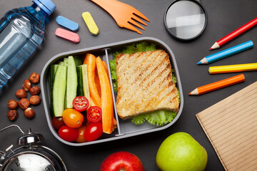 School lunch box and education stationery on stone table
