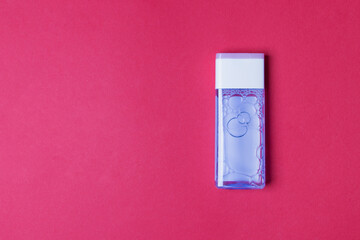 bottle with tonic for health care on red background with copy space