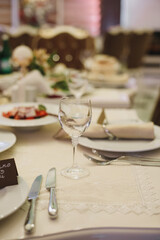 banquet table is decorated with plates, cutlery, glasses, candles and flower arrangements