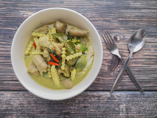 Green curry with fish ball and Coconut Shoots in white bowl on wooden background.Thai food call name 