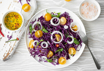 salad of red cabbage, yellow cherry tomatoes and onions